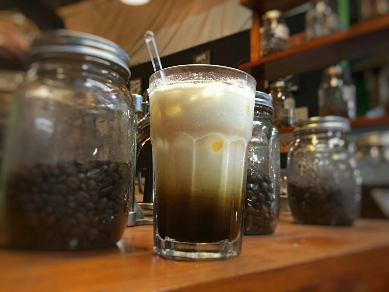 clear drinking glass next to two glass jars